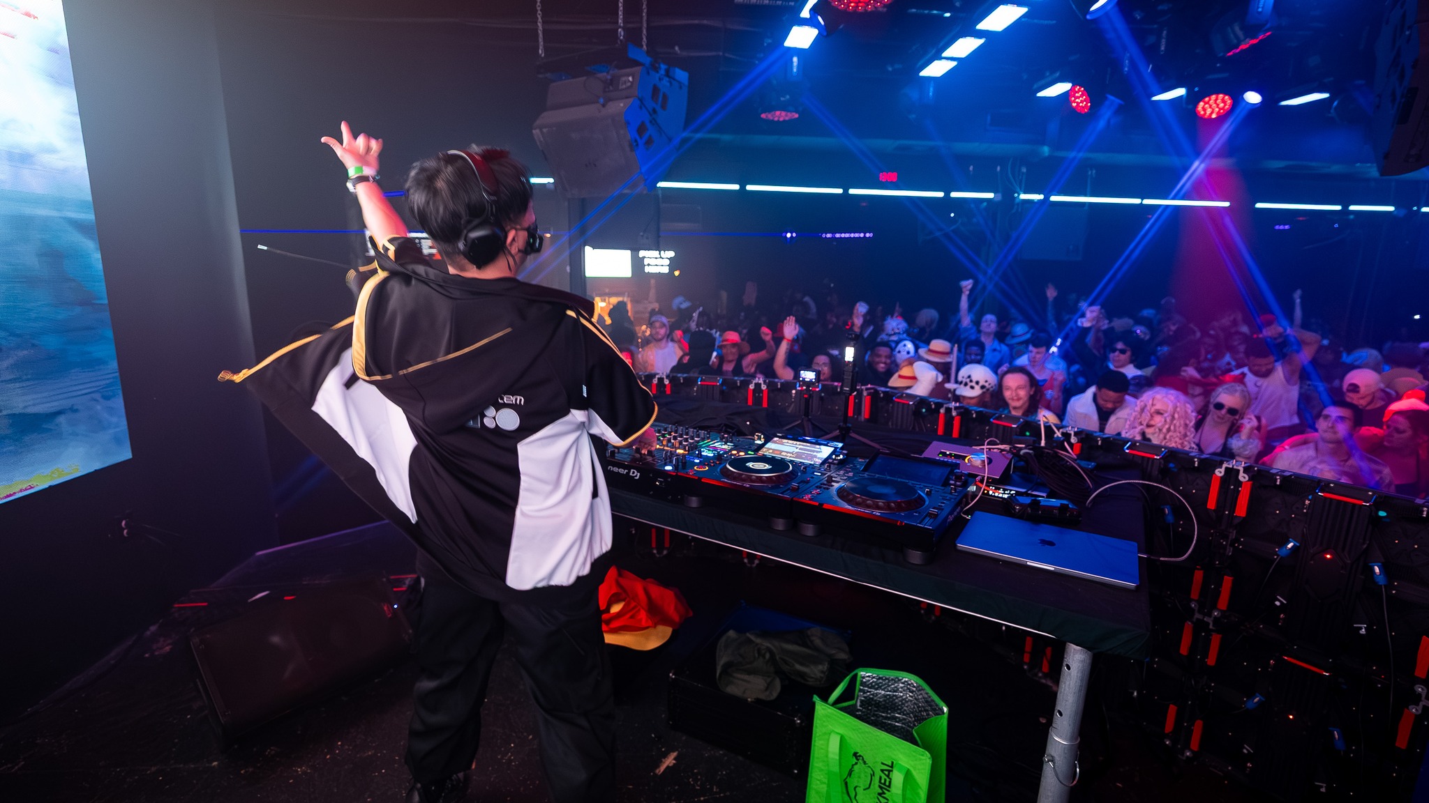NINJ3FF3C7 โ hyping the crowd at an anime rave, blue and purple stage lights with cosplayers in the audience